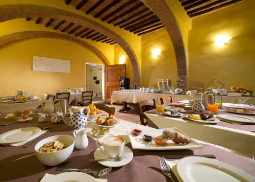 锡耶纳迪瓦里宫酒店的一间用餐室,配有一张带食物盘的桌子