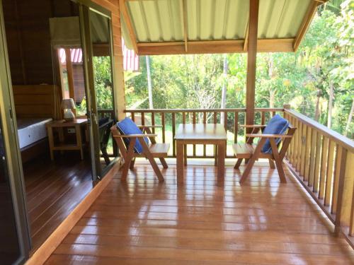 阁遥岛Sabai House Bungalow的一个带桌椅的房屋门廊