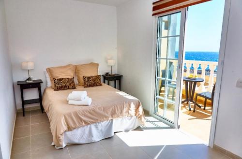厄尔梅达诺Medano Beach Villas的一间卧室设有一张床,享有阳台的景色