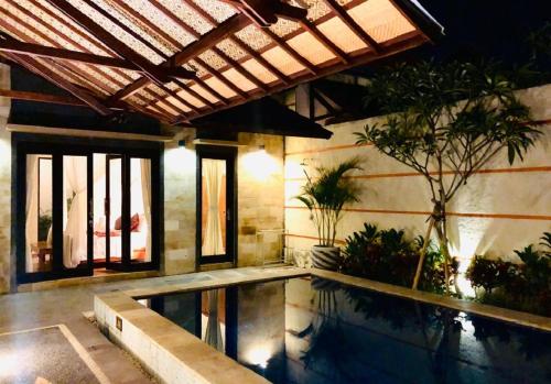 苏卡瓦提Kartika Dahayu Private Pool Villas的一座带游泳池和大楼的房子