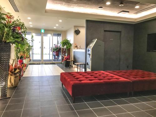 富山Hotel Livemax Toyama的大楼里的一个红色长凳的房间