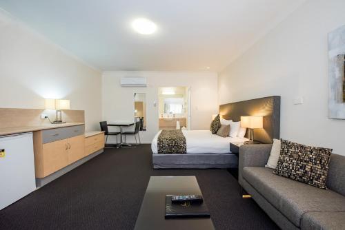麦凯珊瑚岛度假村汽车旅馆的酒店客房,配有床和沙发