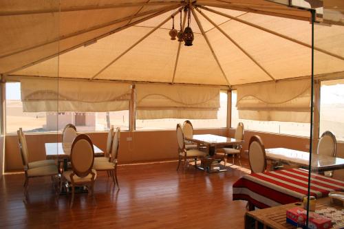 ḨawīyahSafari Dunes Camp的帐篷内带桌椅的用餐室