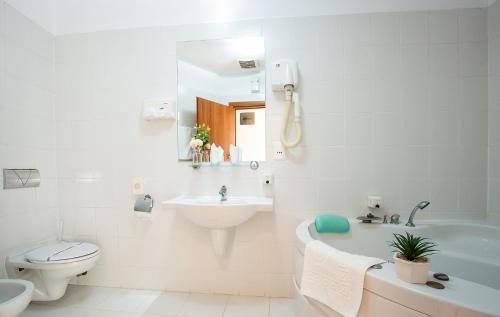 萨图马雷Hotel Dana 2的白色的浴室设有水槽、浴缸和卫生间。