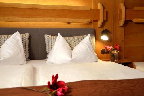 雷特温克尔Hotel Bichlhof的一间卧室配有带白色床单和枕头的床。