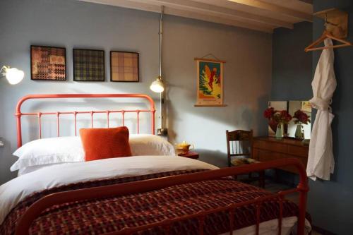 纳伯斯Grain Store Cottage的一间卧室配有一张带橙色枕头的床