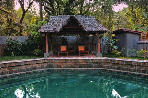 科钦Chittoor Kottaram Royal Mansion- CGH Earth的一个带凉亭和房子的游泳池