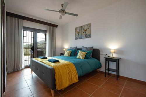 阿洛拉Villa Mantequilla的一间卧室配有一张床和吊扇