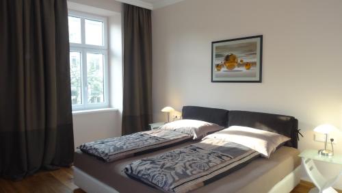 维也纳Sonnberg Design Apartments的卧室内的一张床位,带窗户
