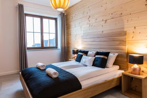 乔尔什滕udanypobyt Apartamenty Czorsztyn Panorama的一间卧室设有木墙和一张带枕头的床。