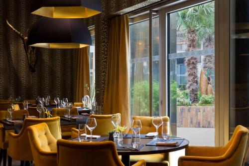 里尔拉布雷沃雅格酒店 - BW普瑞米尔连锁 - 里尔的餐厅设有桌椅和大窗户。