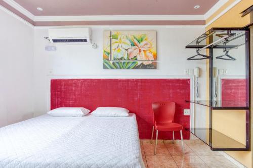 韦斯帕夏诺Ouro Hotel的一间卧室设有一张床和红色的墙壁