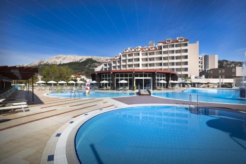 巴斯卡Corinthia Baška Sunny Hotel的大楼前设有大型游泳池的酒店