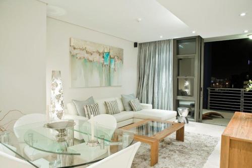 开普敦凯莫尔405B号公寓的客厅配有白色沙发和玻璃桌