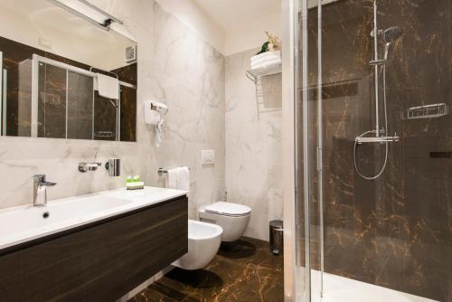 圣贝内代托-德尔特龙托Hotel Regent - In pieno Centro的浴室配有卫生间、盥洗盆和淋浴。