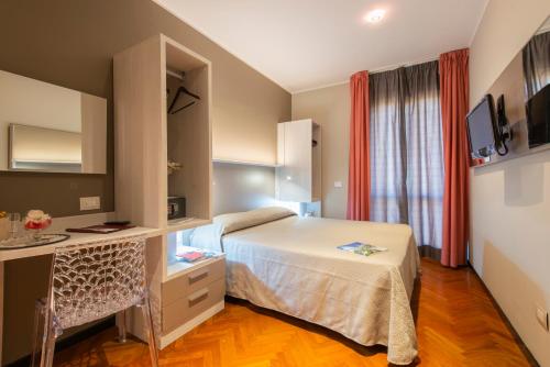 圣贝内代托-德尔特龙托Hotel Regent - In pieno Centro的配有一张床、一张书桌和一扇窗户的酒店客房