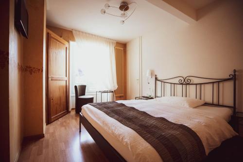 Yvorne奥伯格可姆尔德拉克尼酒店的一间卧室设有一张大床和一个窗户。