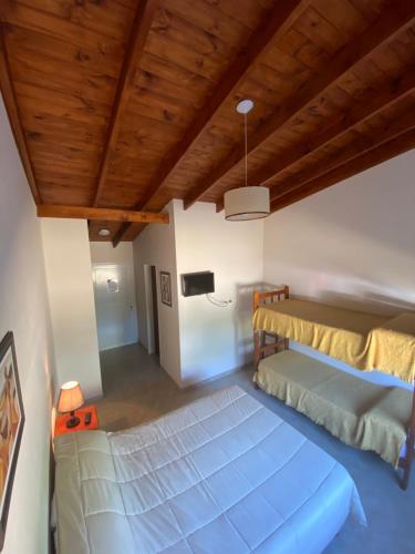埃尔卡拉法特Hotel y Cabañas Las Marías的一间卧室设有一张大床和木制天花板