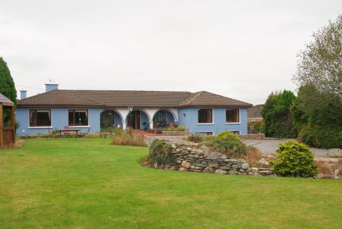 基拉尼戈蒙斯乡村酒店的庭院里一座带石墙的蓝色房子