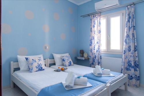 帕拉斯波罗斯Port View House的配有两张床铺的蓝色墙壁和窗户