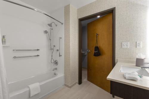 费耶特维尔Holiday Inn Express & Suites - Fayetteville South, an IHG Hotel的带浴缸、水槽和淋浴的浴室
