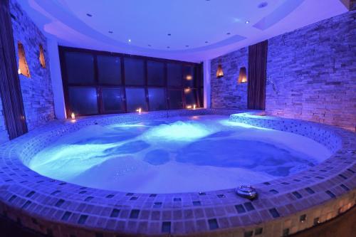 马丘比丘卡萨得索尔麦池皮池酒店的一个带灯光的客房内大型按摩浴缸