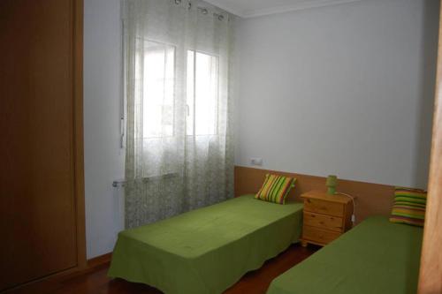 蒙福特·德·莱蒙斯La Casa de Lines的一间卧室设有两张绿色的床和窗户