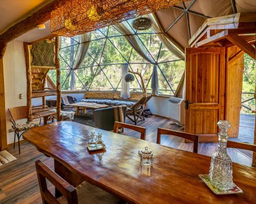 圣阿方索Cascada de las Animas的一间带木桌和大窗户的用餐室