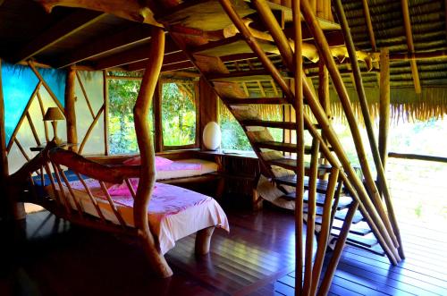 Teahupoo瓦尼拉旅舍的一间卧室配有一张床,铺有木地板