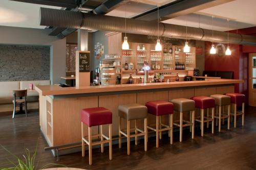 梅德巴赫特洛尔布奥豪斯酒店的餐厅的酒吧,有红色凳子