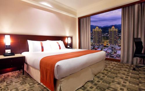 深坑台北海湾假日酒店的一间酒店客房,设有一张大床和一个大窗户