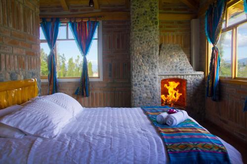科塔卡奇Watzara Wasi Cottage Familiar Camprestre Y Lofts en Cotacachi的一间卧室设有一张带壁炉的床
