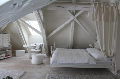 Rüeggisberg加斯特维奇别墅度假酒店的一间卧室配有一张天蓬床和一张桌子