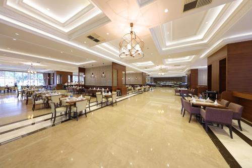 贝尔迪比Juju Premier Palace Hotel Ex Amara Premier Palace的一间在房间内配有桌椅的餐厅