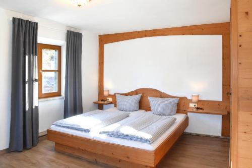 普夫龙滕Alps Hostel的一间卧室设有一张木床和大窗户
