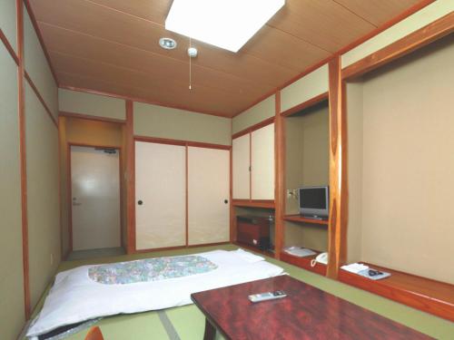 大町市纳库罗斯传统日式旅馆 的小房间设有一张床和一张桌子