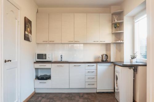 考纳斯Agnės svečių namai的厨房配有白色橱柜和微波炉