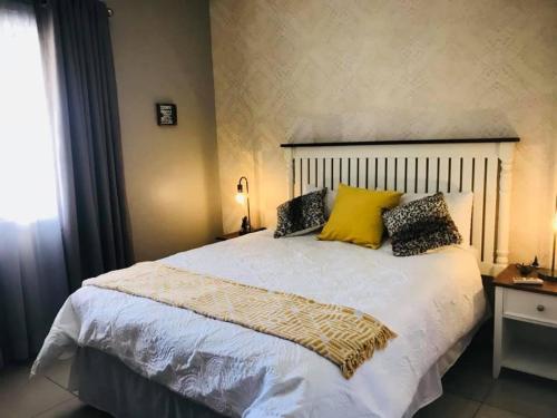 马翁GardenView Holiday Home的卧室配有一张带黄色枕头的大型白色床。