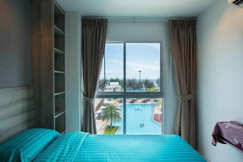 Ban Tha FatGrandBlue Condominium Sea View的一间卧室设有享有泳池景致的窗户