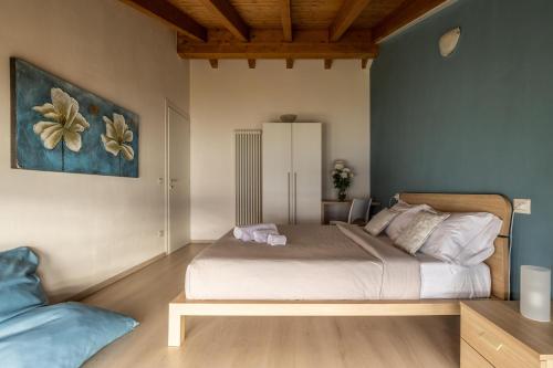 韦尔卡纳伊尔加迪诺迪罗利酒店的卧室配有一张床,墙上挂有绘画作品