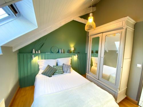 Yffiniac格勒尼耶度假屋的卧室配有白色的床和绿色的墙壁