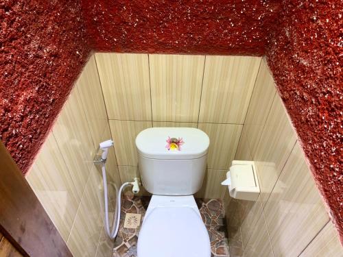 蓝梦岛Nusa Garden Homestay的一间红色墙壁上的小浴室,内设卫生间