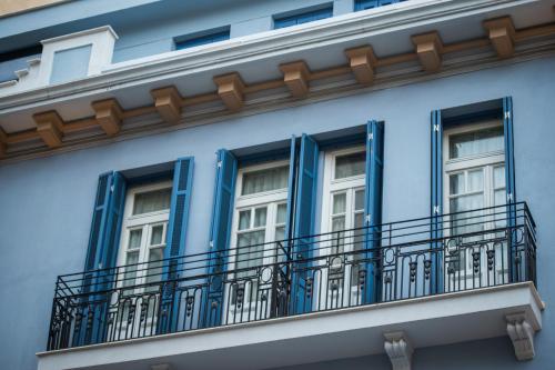 塞萨洛尼基Bahar Boutique Hotel的蓝色的建筑,设有窗户和阳台