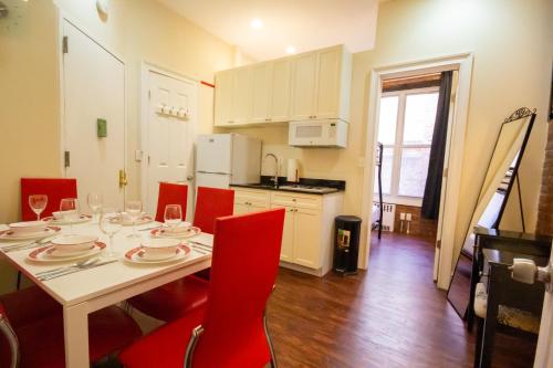 纽约STUDIO PLUS - 2 Bedroom Apartment in Midtown的配有红色椅子的餐桌和厨房