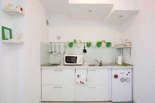 杜布罗夫尼克A bright hideaway的厨房配有白色橱柜和微波炉