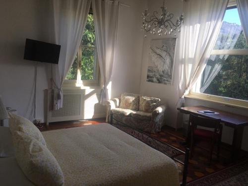 莱科天鹅别墅旅馆的一间卧室配有一张床、一把椅子和窗户。
