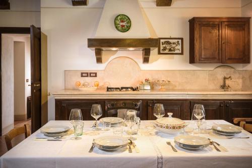 皮恩扎阿格里图丽斯莫塞利托酒店的厨房配有带盘子和酒杯的桌子