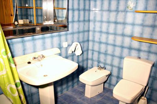 奥尔塔-德圣胡安Casa Toni的蓝色瓷砖浴室设有水槽和卫生间