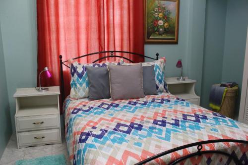 罗索The AnSwin Apartment的一间卧室配有一张带五颜六色被子的床