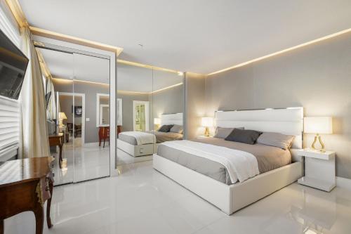 棕榈滩ORCHID SUITES - Historic Palm Beach Hotel Condominium的卧室配有一张白色大床和镜子